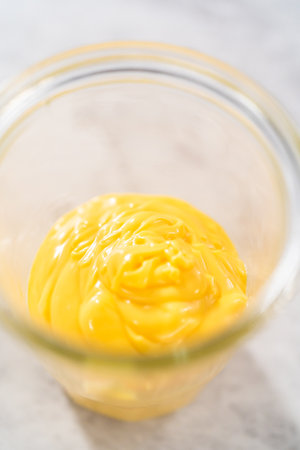 Melted yellow chocolate chips in a glass jar on the kitchen counter.の写真素材