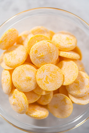 Yellow chocolate chips in a small glass bowl on the kitchen counter.の写真素材