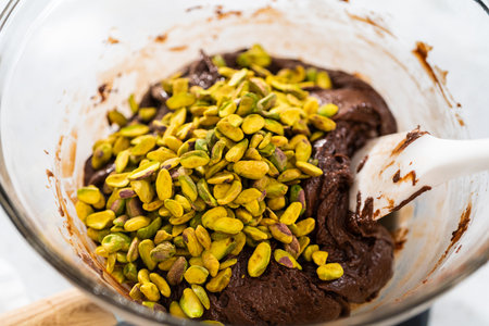 Melting white chocolate chips and other ingredients in the double boiler to prepare chocolate pistachio fudge.の写真素材