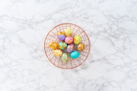 Colored and painted with gold hard-boiled eggs on a marble background.