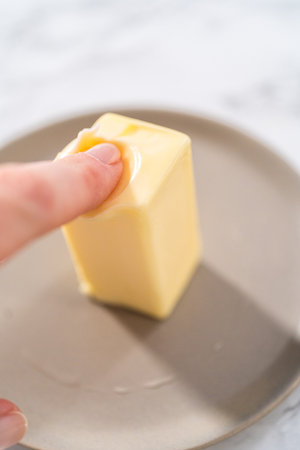 Softening stick of unsalted butter under a hot glass.の写真素材