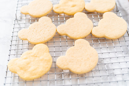 Cooling panda-shaped shortbread cookies on a cooling rack at the kitchen counter.