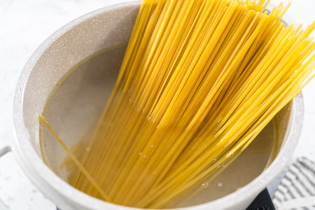 Boiling linguine pasta in a large cooking pot.の写真素材