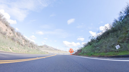 Vehicle is cruising along the Cuyama Highway under the bright sun. The surrounding landscape is...
