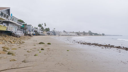 Walking along the shore of Miramar Beach, California, the overcast winter sky creates a tranquil and reflective atmosphere.の写真素材
