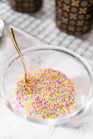 Decorating mini Easter bread kulich with sprinkles and meringue bird-shaped cookies.