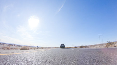 Embarking on a road trip from Nevada to California, driving on Highway 15 during the day offers scenic views and an exciting journey between states.の写真素材