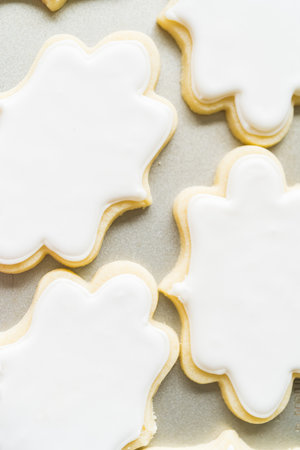 A captivating display of sugar cookies, beautifully flooded with glossy white royal icing, perfect for any celebration or just a simple, sweet treat. An embodiment of home baking at its finest.の写真素材