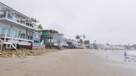 Walking along the shore of Miramar Beach, California, the overcast winter sky creates a tranquil and reflective atmosphere.の写真素材