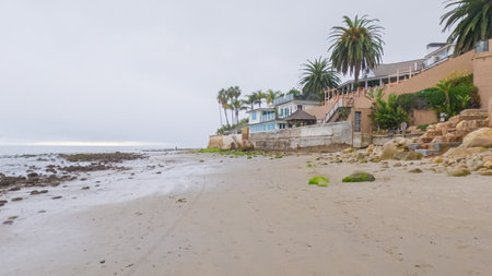 Walking along the shore of Miramar Beach, California, the overcast winter sky creates a tranquil and reflective atmosphere.の写真素材