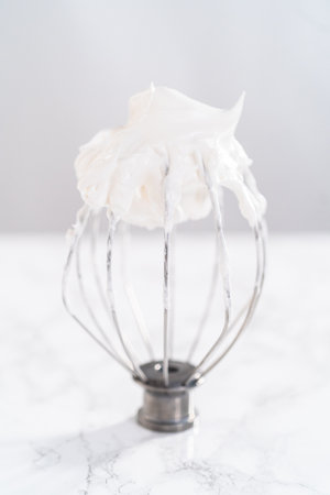 Mixing ingredients in kitchen electric mixer to bake meringue cookies.の写真素材