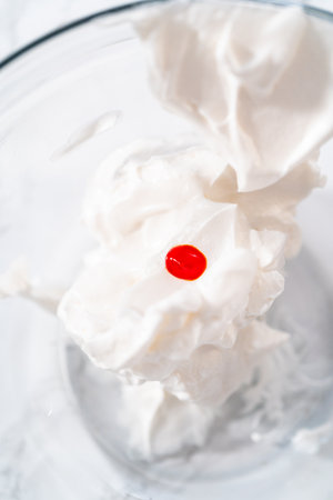 Mixing food coloring into the meringue to bake meringue cookies.の写真素材