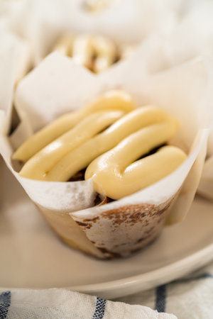 Freshly baked no-yeast cinnamon roll cupcakes filled with cinnamon filling and chopped pecans.の写真素材