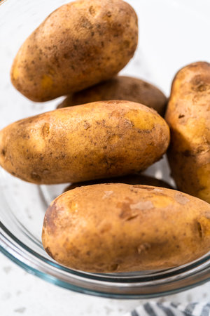 Peeling and cutting Russet potatoes to make potato salad.の写真素材
