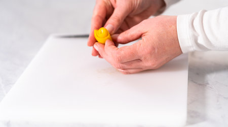 Preparing lemon swirls from the organic lemon to decorate the cocktail.の写真素材
