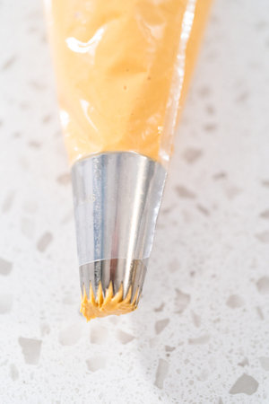Transferring freshly whipped dulce de leche buttercream frosting into a piping bag.