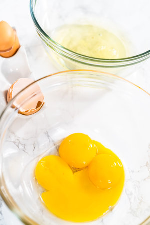 Separating egg whites and yolks to bake meringue cookies.