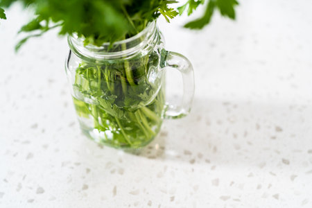Storing fresh parsley in a jar with water.の写真素材