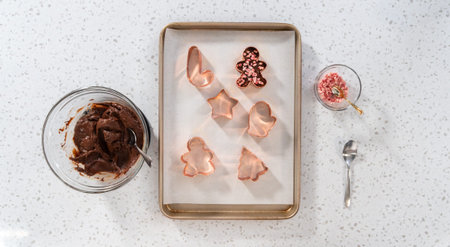 Flat lay. Filling cookie cutter with fudge mixture to prepare Christmas cookie-cutter peppermint...