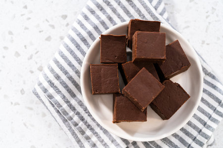 Homemade plain fudge pieces on a white ceramic plate.の写真素材