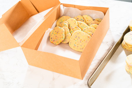 With precision, the woman is carefully arranging the sugar cookies, filled with dough-mixed...