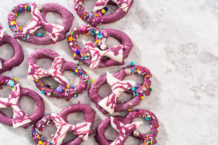 Homemade chocolate-dipped pretzel twists decorated with colorful sprinkles and chocolate mermaid...