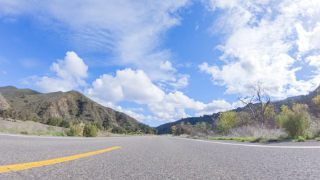 Vehicle is cruising along the Cuyama Highway under the bright sun. The surrounding landscape is...
