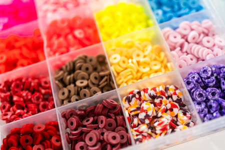 Assorted clay bead boxes neatly arranged on a white table, awaiting a creative kids craft project.