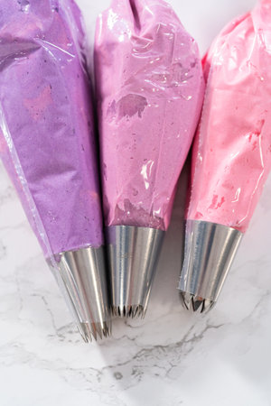 Ombre pink buttercream frosting in a piping bag with a jumbo metal piping tip.