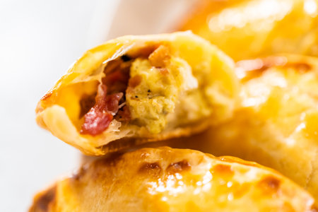 Freshly baked breakfast empanadas with eggs and sweet potato on the kitchen counter.の写真素材
