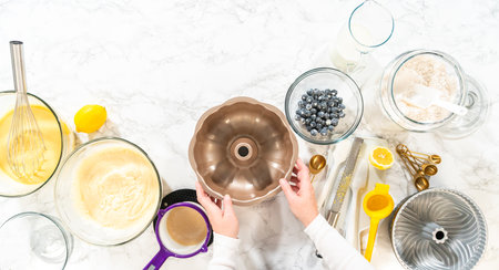 Flat lay. Carefully apply vegetable shortening to the bundt cake pan, ensuring a smooth, non-stick baking experience.の写真素材