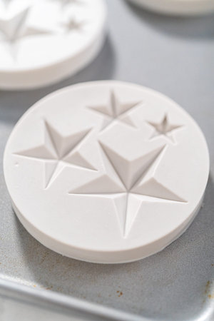 Filling silicone mold with white melted chocolate to make chocolate chocolate stars for American...
