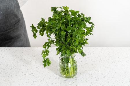 Storing fresh parsley in a jar with water.の写真素材