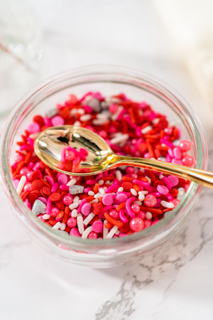 Decorating heart-shaped sugar cookies with pink and white royal icing for Valentines Day.の写真素材
