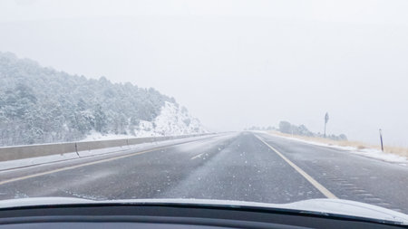 POV-Electric vehicle is captured deftly navigating the I-70 highway during a winter storm in Western Colorado.の写真素材