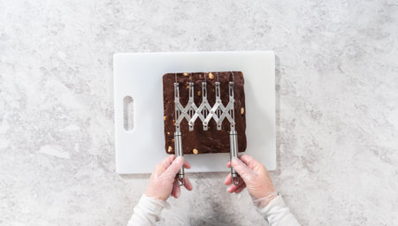Flat lay. Scoring chocolate macadamia fudge using a wheel dough cutter for cutting into small square pieces.の写真素材