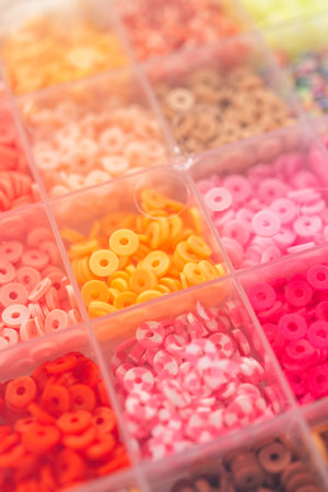 Assorted clay bead boxes neatly arranged on a white table, awaiting a creative kids craft project.