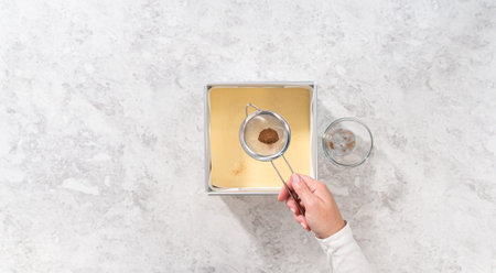 Flat lay. Pouring fudge mixture into the square cheesecake pan lined with parchment paper to prepare...