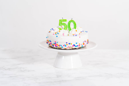 Little birthday cake for 50th birthday on a white cake plate.