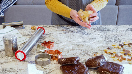 Using an adjustable rolling pin to roll out gingerbread cookie dough on the elegant marble counter in a modern kitchen, getting ready for festive holiday baking.の写真素材