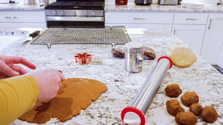Using various festive cookie cutters, were cutting out charming gingerbread cookies from the rolled...