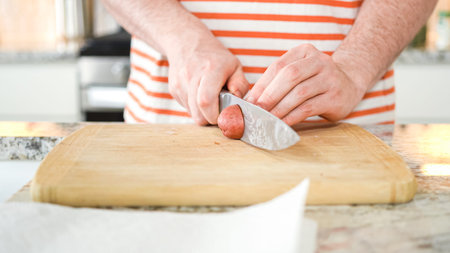In the contemporary ambiance of a modern kitchen, a young man engages in dinner preparations. His...