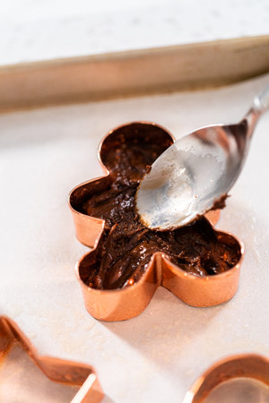 Filling cookie cutter with fudge mixture to prepare Christmas cookie-cutter peppermint fudge.の写真素材