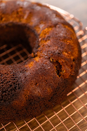 The gingerbread bundt cake cools gracefully on a wire rack, awaiting its sweet caramel frosting.の写真素材