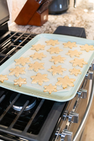 Letting delightful snowflake-shaped sugar cookies cool after baking, preparing them for festive...