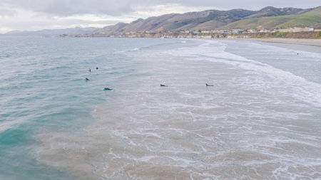 As the sun sets, Pismo Beach transforms into an enchanting winter wonderland with an empty, expansive sandy shore, bathed in golden hues, and the soothing sounds of the waves creating a tranquil atmosphere.の写真素材