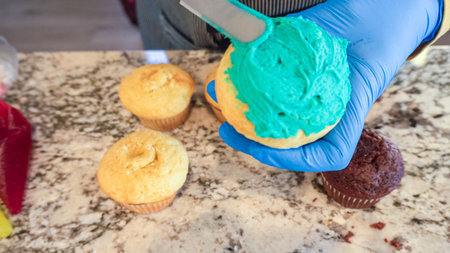 Using buttercream frosting, vanilla and chocolate cupcakes are intricately decorated to resemble various types of cactuses, creating a delightful and visually engaging dessert that showcases creativity and skill in baking.の写真素材