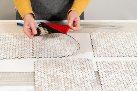 In the process of mounting peel and stick mosaic tiles onto a foam board, perfect for enhancing a...