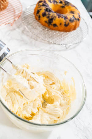 Skillfully combine ingredients using a hand mixer to prepare a rich, smooth cream cheese buttercream...