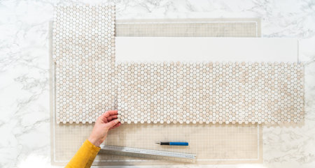 In the process of mounting peel and stick mosaic tiles onto a foam board, perfect for enhancing a...